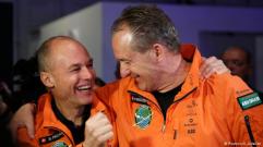 Piccard and Borschberg in orange jumpsuits
